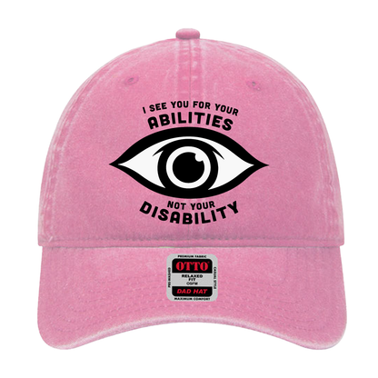 Pink dad hat featuring an eye graphic and the text “I see you for your abilities, not your disability.”